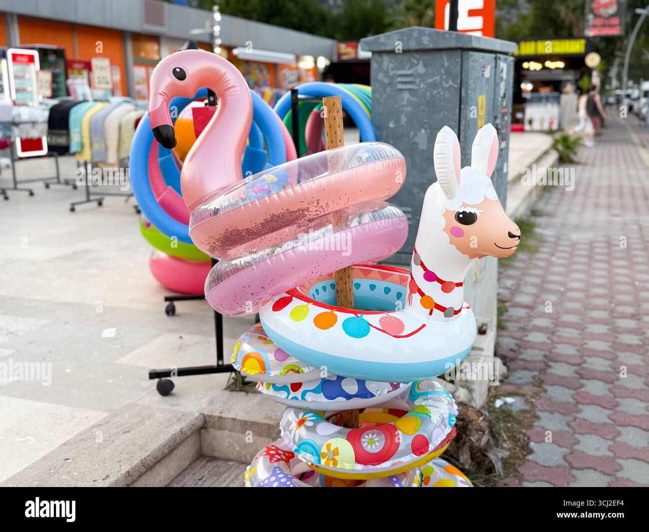 Flotteurs gonflables de flamant rose et de lama dans un magasin de rue. Décoration ludique, amusement de l'eau, et esprit de vacances d'été. Banque D'Images