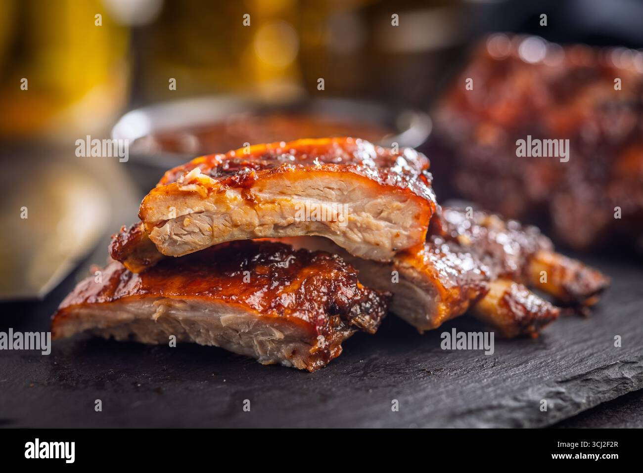 Côtes glacées BBQ de porc sur une table noire. Banque D'Images