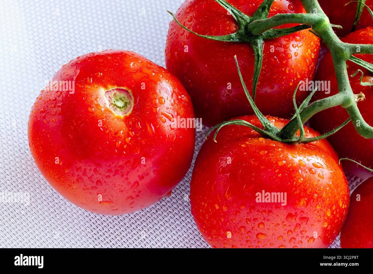 Campari est un type de tomate hybride connu pour sa jutosité, son taux élevé de sucre, sa faible acidité et son manque de farineux. Camparis sont rouge profond et plus grand tha Banque D'Images
