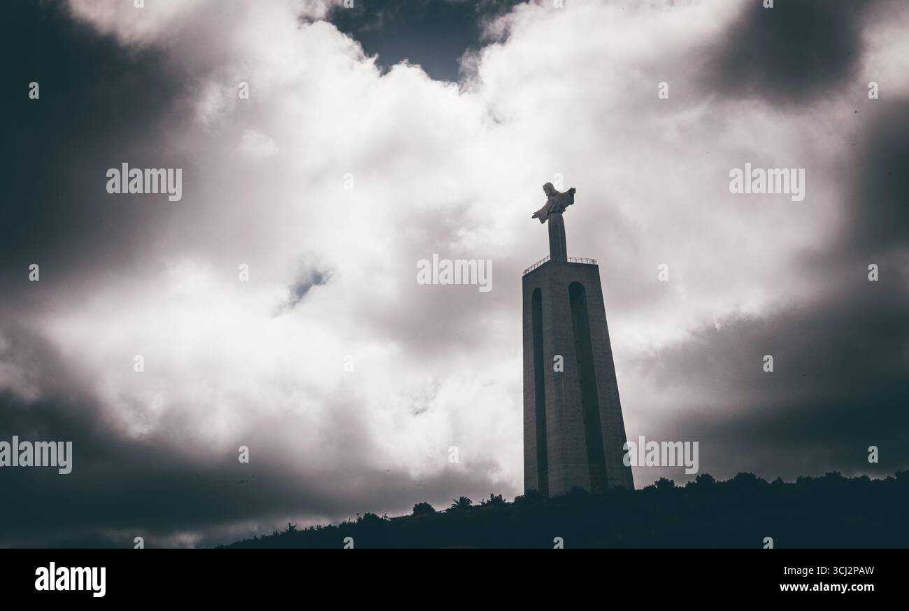 Une photo en angle bas du sanctuaire Cristo Rei, un monument célèbre à Almada, près de Lisbonne. La photographie met en valeur la statue colossale du Christ sur son Banque D'Images