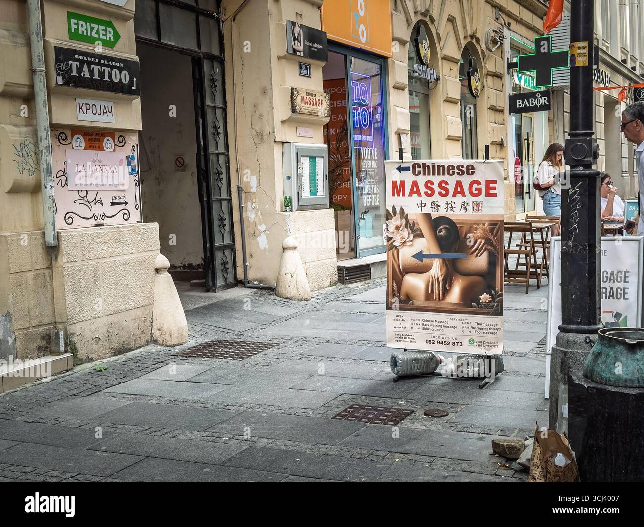 BELGRADE, SERBIE - 22 MARS 2025 : panneau autoportant annonçant le massage chinois dans un bâtiment du centre de Belgrade, Serbie ; panneau bilingue et flèche Banque D'Images