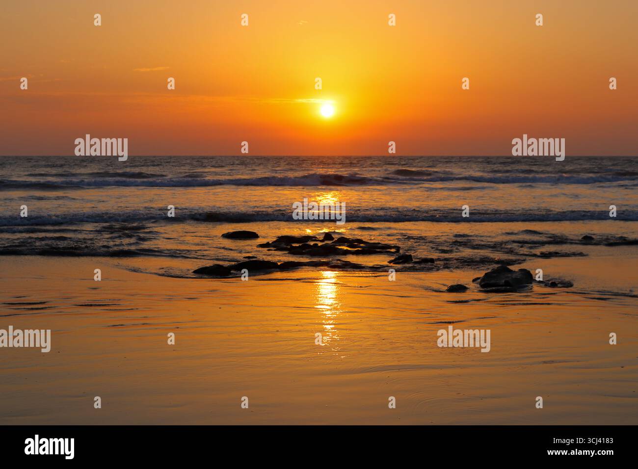 Une vue imprenable sur le coucher de soleil sur l’horizon à Inani Beach, Cox’s Bazar, Bangladesh, avec des reflets dorés chatoyants sur les vagues et R Banque D'Images