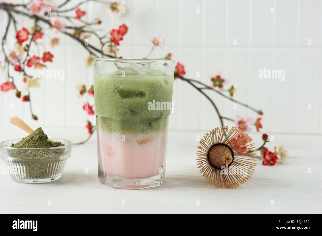 Thé vert glacé Sakura Matcha lait glacé sur table blanche Banque D'Images