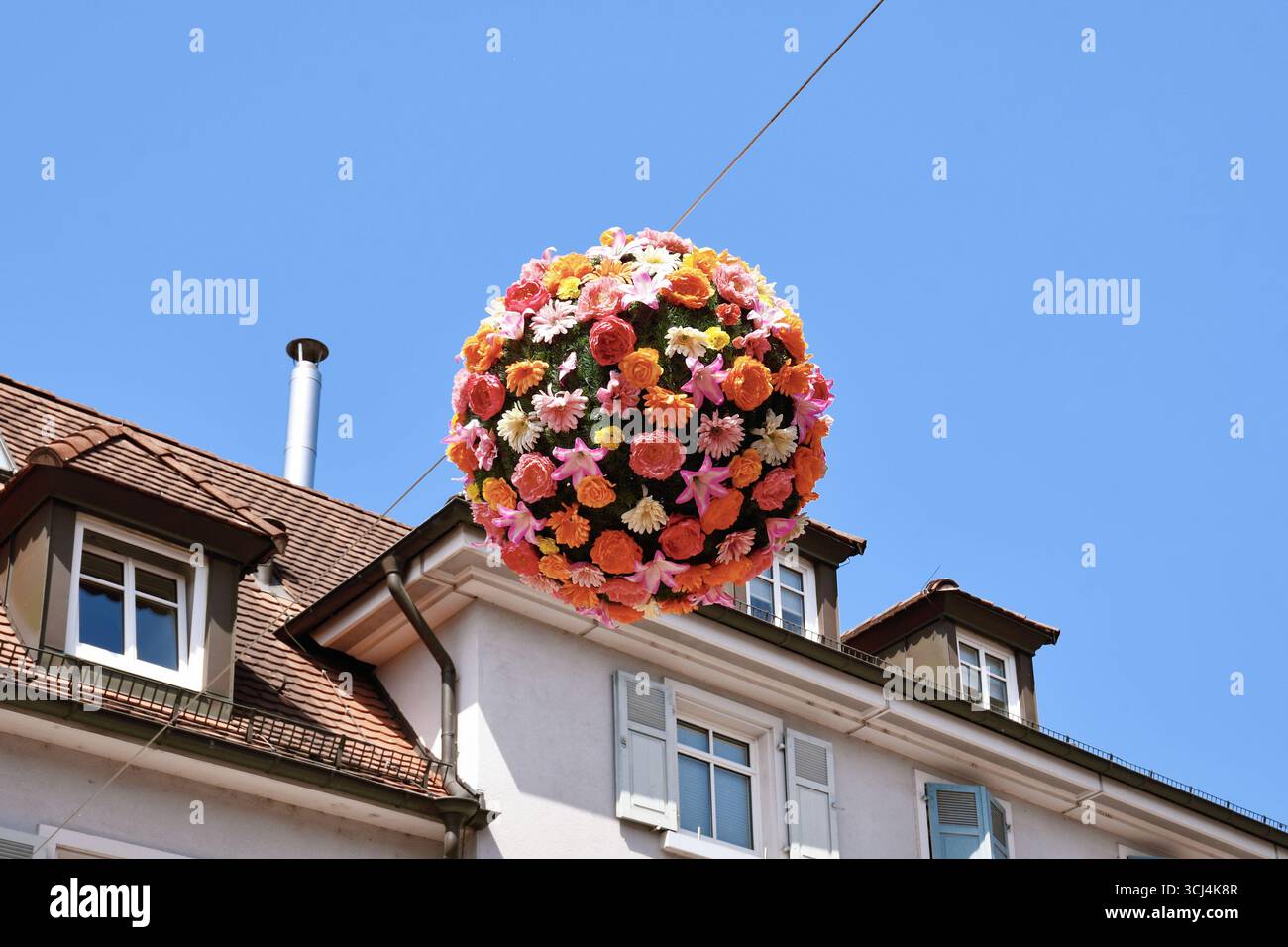Ettlingen, Allemagne - 13 août 2025 : sphère florale de fleurs suspendues au-dessus de la rue comme décoration d'été Banque D'Images