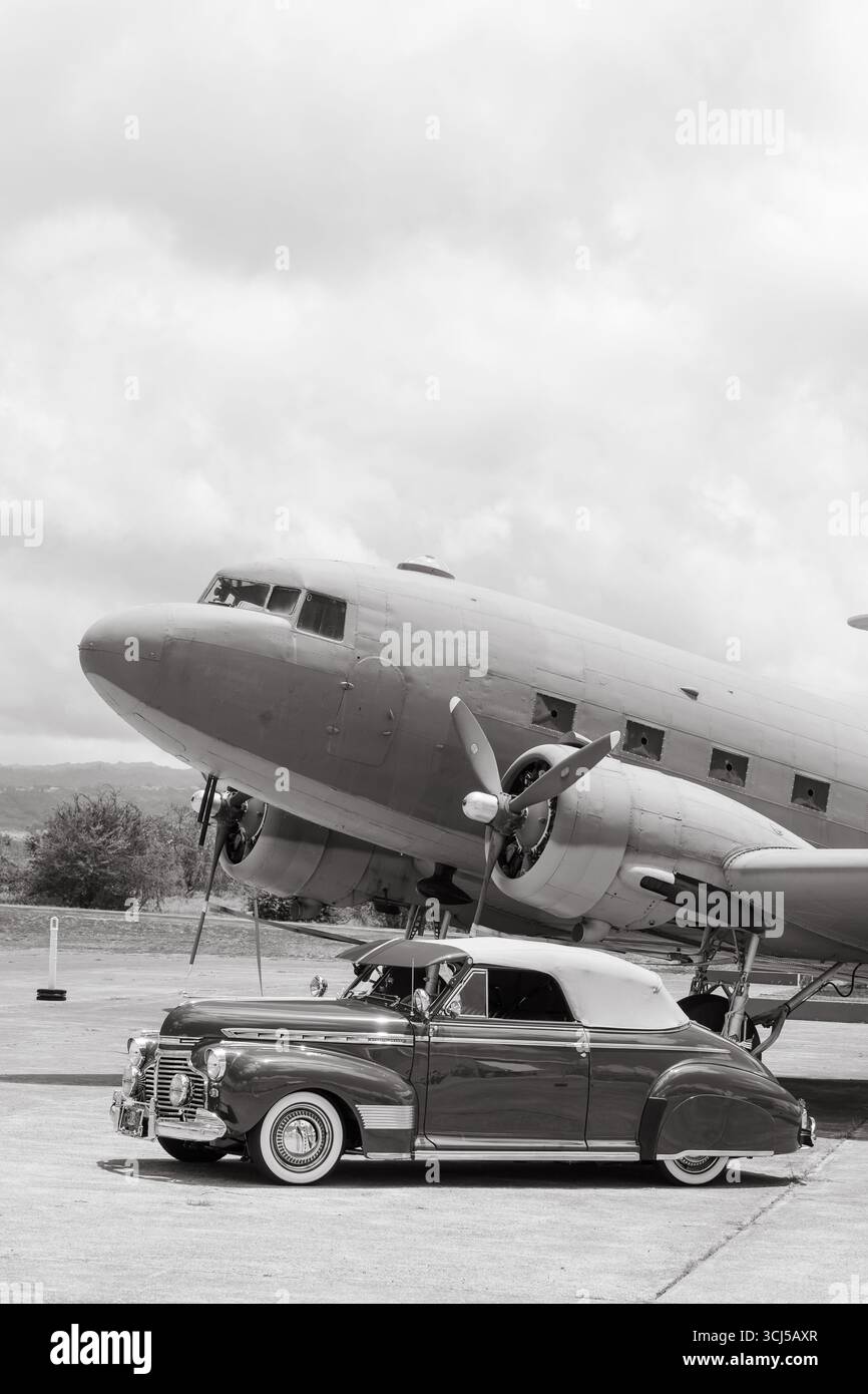 Noir et blanc d'une voiture vintage garée par un avion vintage Banque D'Images Noir et blanc d'une voiture vintage garée par un avion vintage Banque D'Images