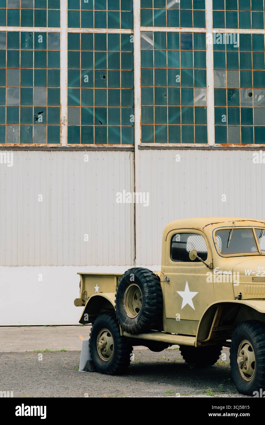 Camion militaire jaune de la seconde Guerre mondiale devant le hangar d'avions à Pearl Harbor Banque D'Images