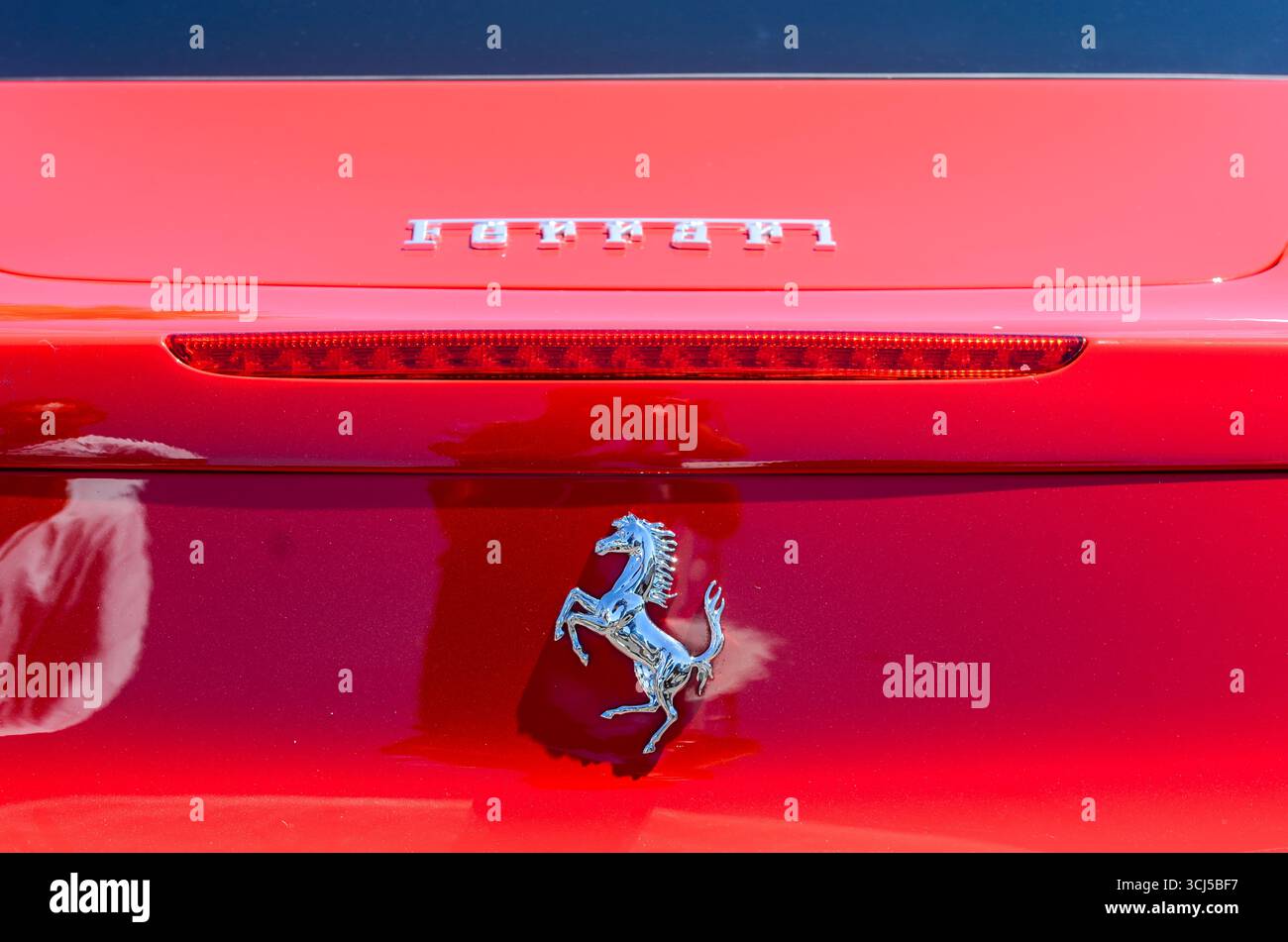 Gros plan d'une Ferrari rouge vif avec l'emblème emblématique du cheval qui prante Banque D'Images