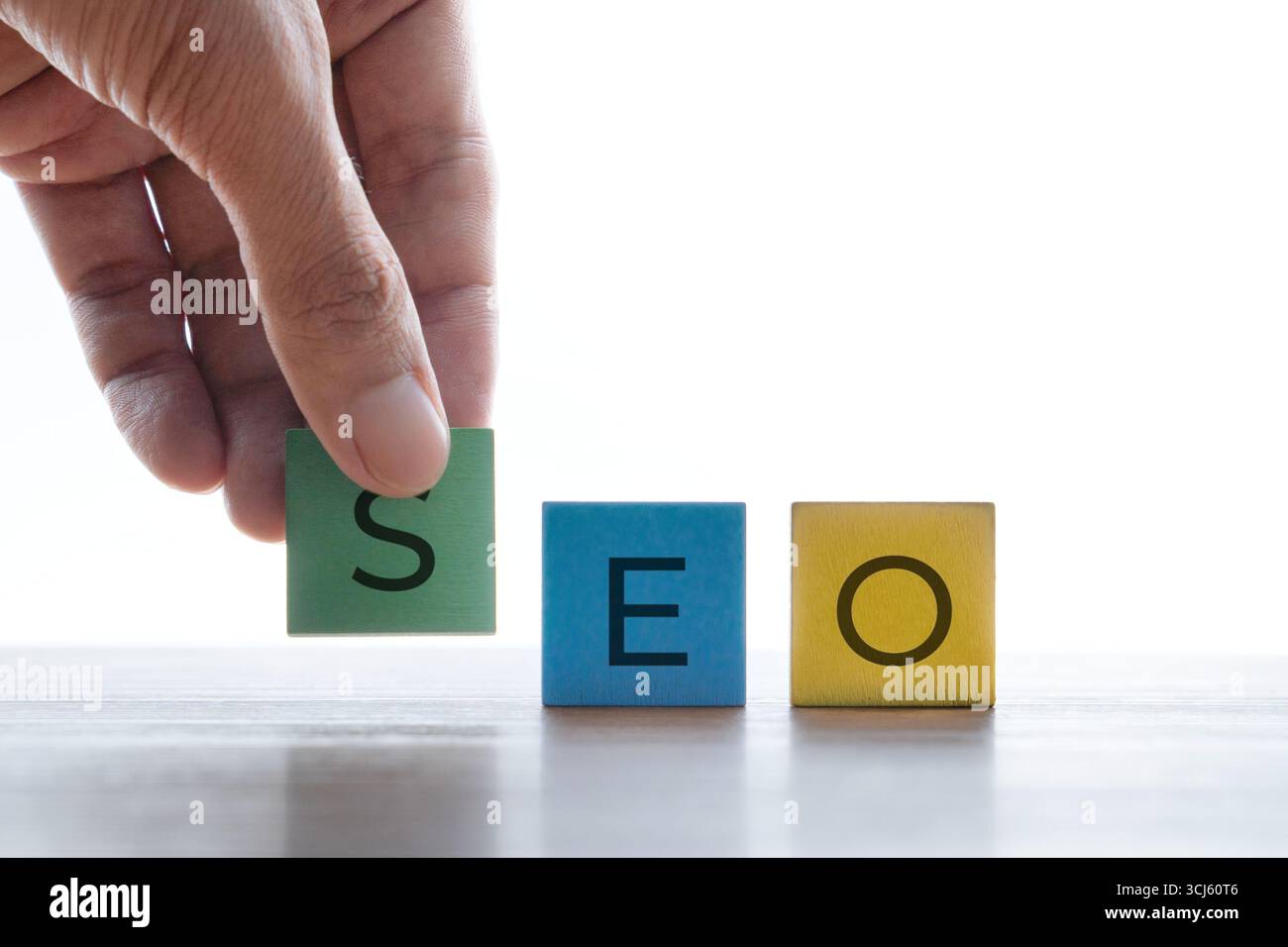 Une main plaçant un bloc de bois avec la lettre S à côté de la lettre E et O. SEO ou Search Engine optimisation, stratégie marketing et affaires numériques Banque D'Images