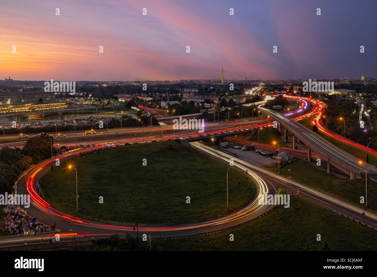 Coucher de soleil à Washington DC - cette photographie à longue exposition prise au crépuscule capture les traînées lumineuses des véhicules sur un réseau complexe d'autoroutes et de rampes. Banque D'Images