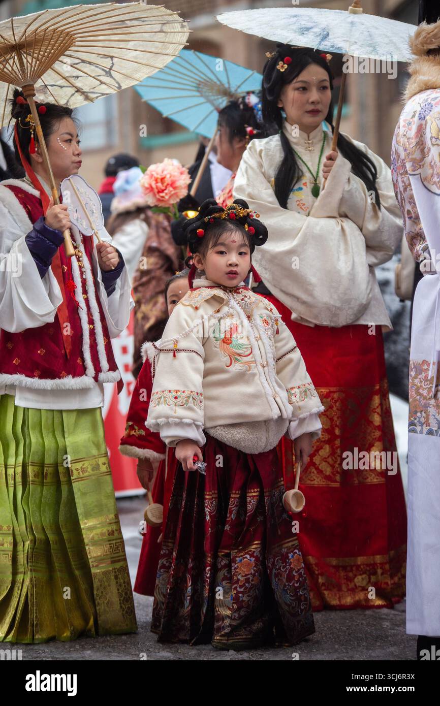 Enfants et adultes vêtus de vêtements chinois traditionnels avec parasols au défilé du nouvel an lunaire, Vancouver 2025 Banque D'Images