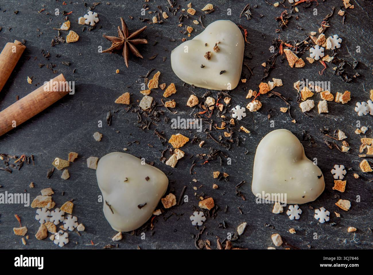 Biscuits en forme de coeur et épices disposés sur un fond d'ardoise grise Banque D'Images