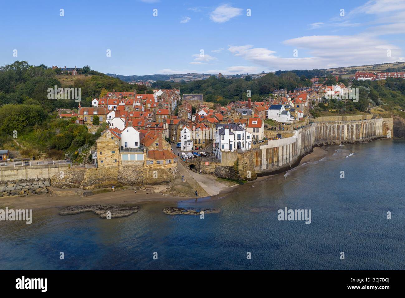 Image aérienne de la baie de Robin des bois le matin, montrant le village de pêcheurs historique avec des maisons au toit rouge et des murs de pierre. Banque D'Images