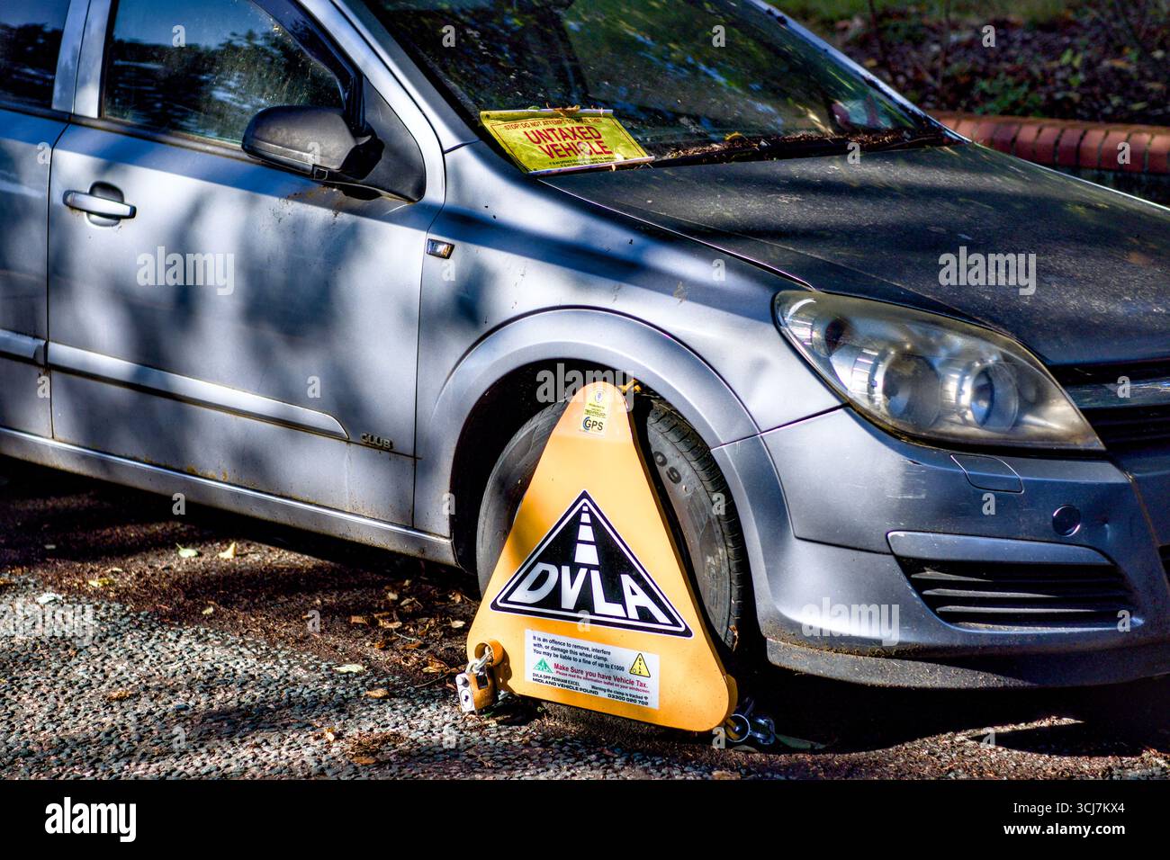 Roue de véhicule bloquée parce qu'elle n'est pas taxée sur la voie publique, Watford, Hertfordshire, Angleterre, Royaume-Uni Banque D'Images