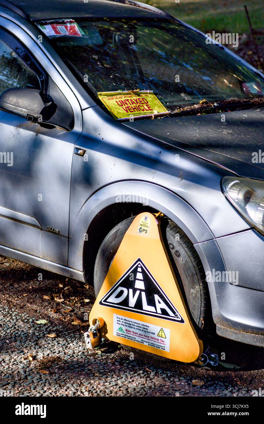 Roue de véhicule bloquée parce qu'elle n'est pas taxée sur la voie publique, Watford, Hertfordshire, Angleterre, Royaume-Uni Banque D'Images