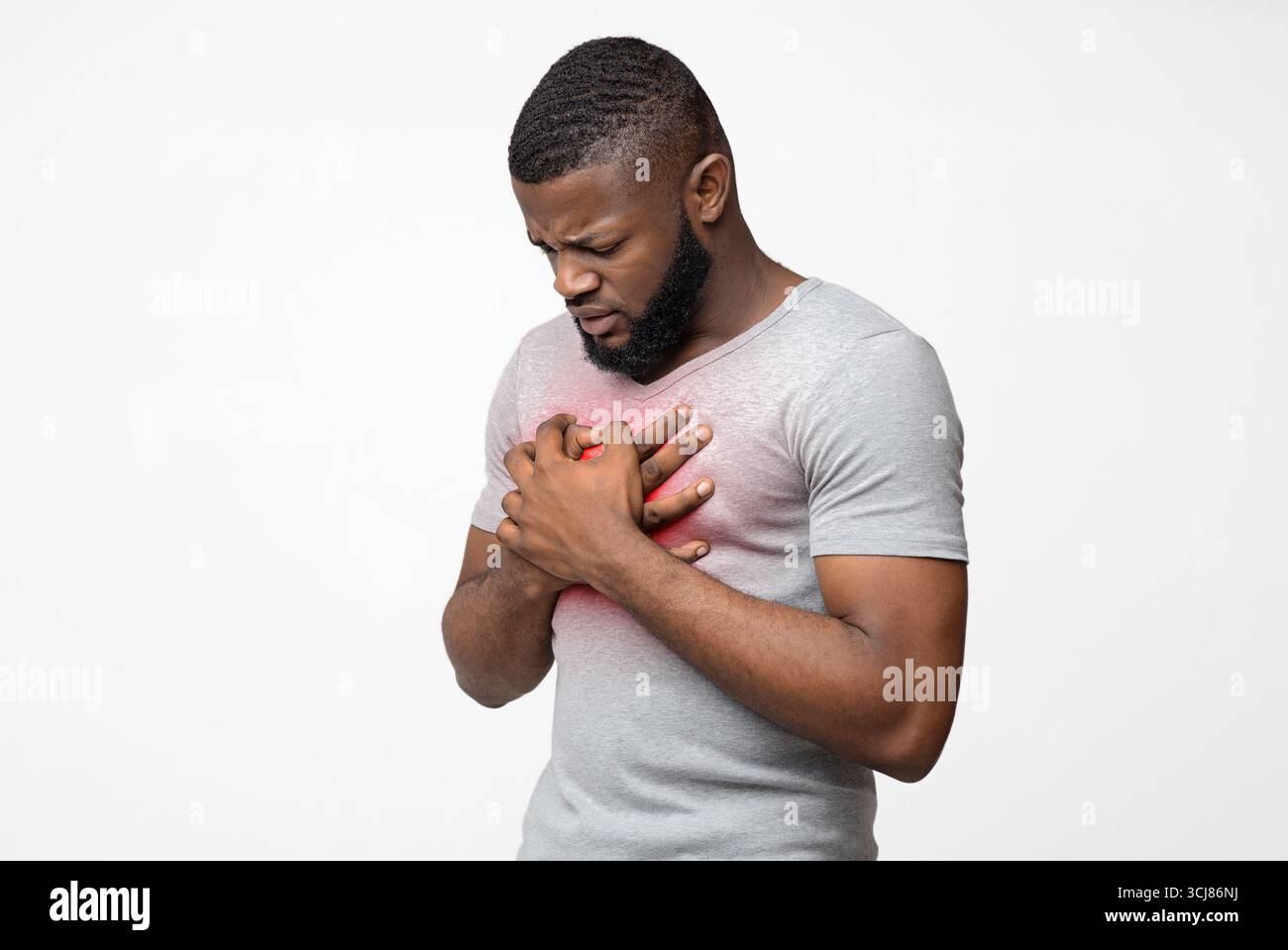 Triste jeune homme afro frottant sa poitrine Banque D'Images