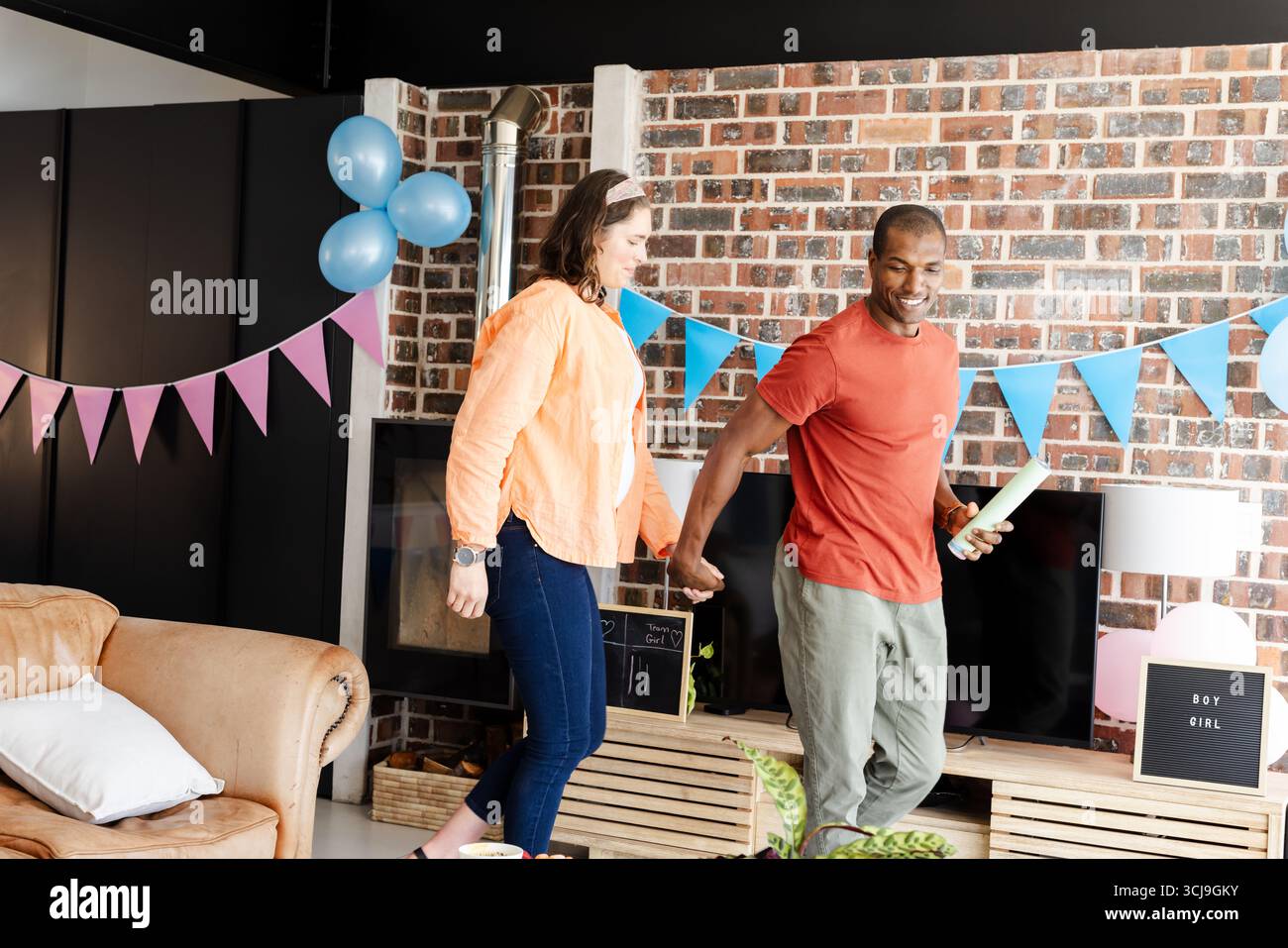 Couple célébrant le genre révéler la fête à la maison avec des expressions joyeuses Banque D'Images