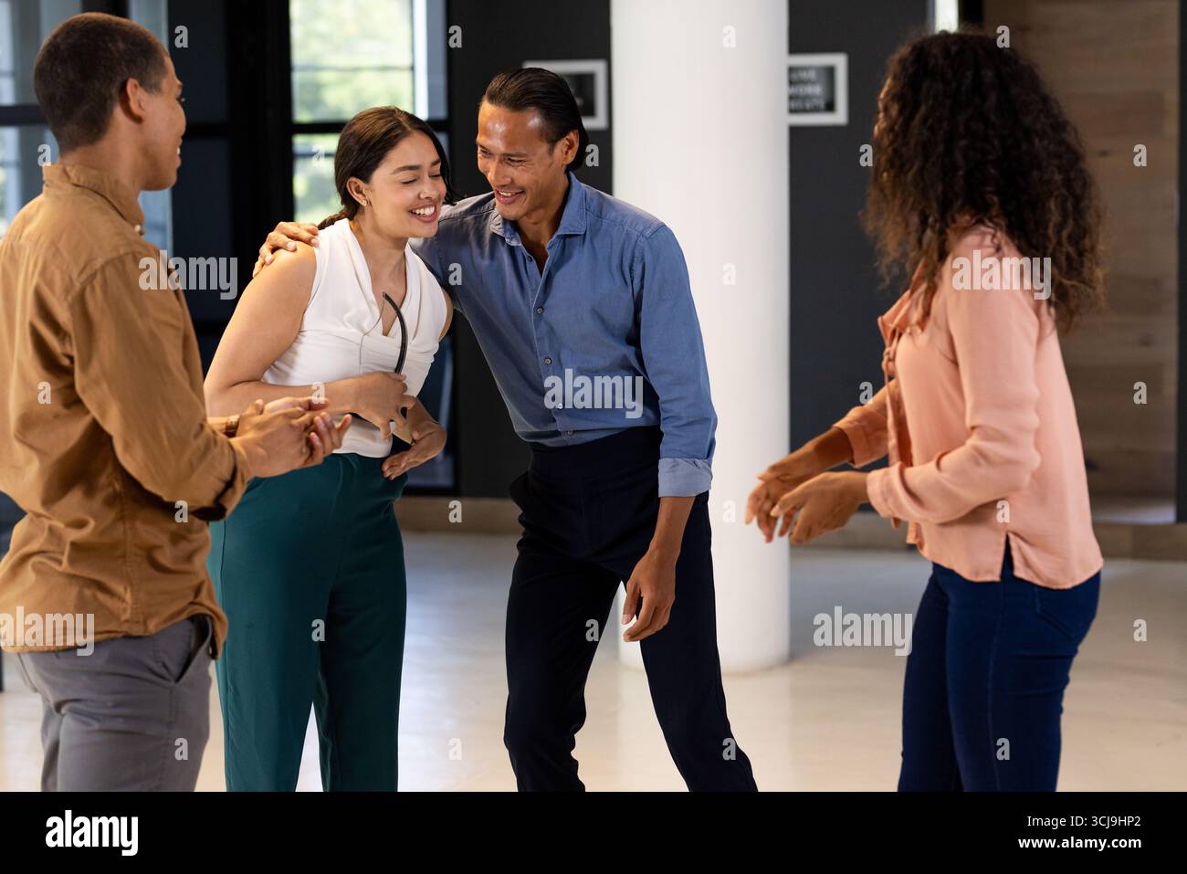 Les collègues rient et tissent des liens lors d'une séance informelle de consolidation d'équipe au bureau Banque D'Images