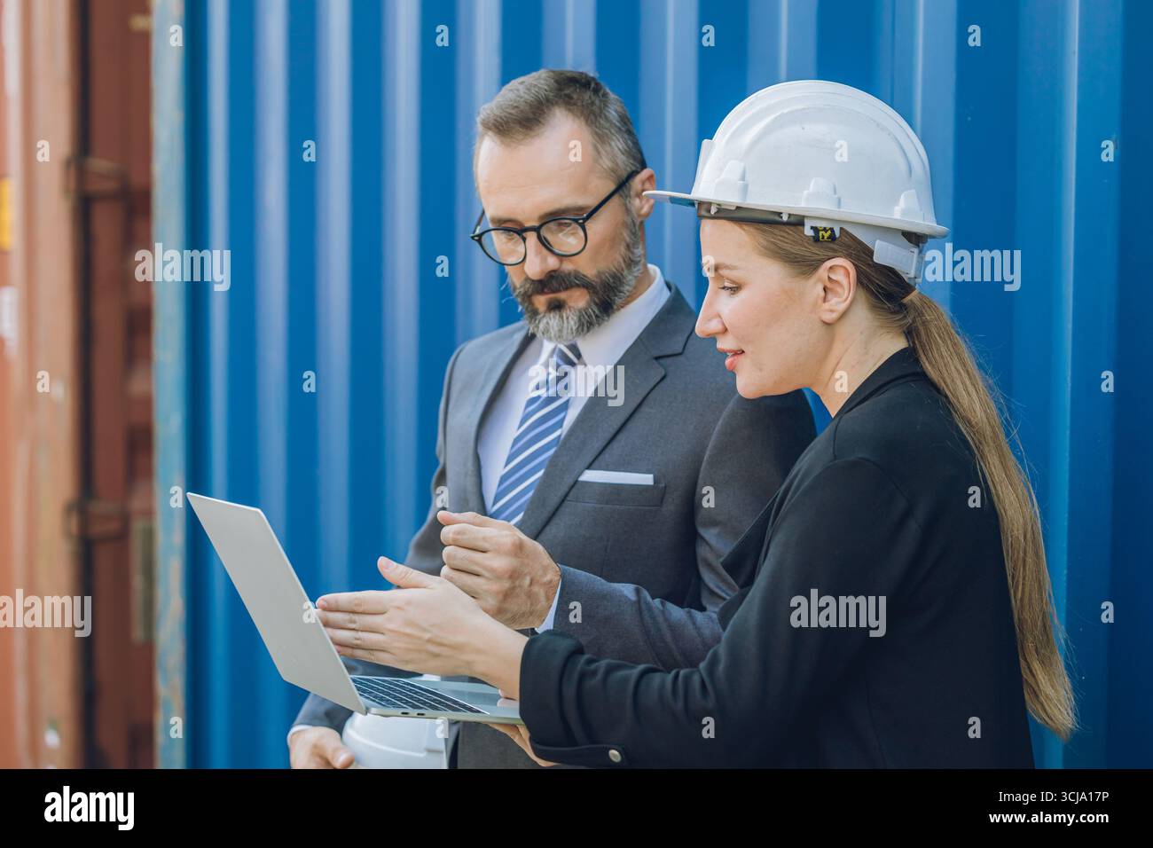 Équipe de gestionnaire d'affaires travaillant dans la cour de conteneurs, les gens de l'industrie d'affaires de logistique d'expédition, secrétaire féminine présente des informations à partir d'un ordinateur portable Banque D'Images