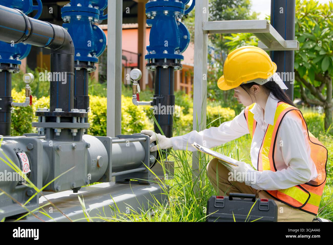 Le travail sur le terrain de technicien d'ingénieur vérifie la nouvelle installation des pompes à cavité progressive avec le système de tuyau de vanne d'eau haute pression à l'extérieur Banque D'Images