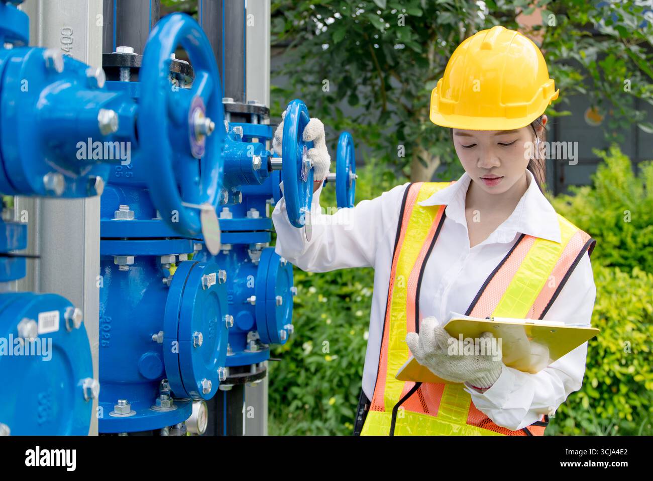 Le travail sur le terrain de technicien d'ingénieur vérifie la nouvelle installation des pompes à cavité progressive avec le système de tuyau de vanne d'eau haute pression à l'extérieur Banque D'Images