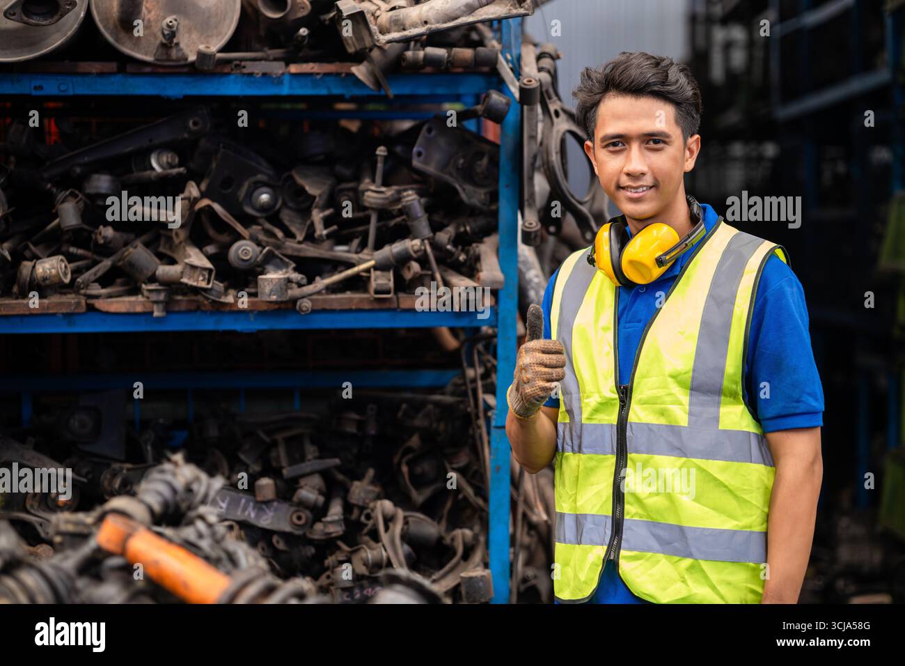Ingénieur masculin asiatique confiant jeune travailleur debout pouces vers le haut sourire heureux pour profiter de travailler en usine Banque D'Images