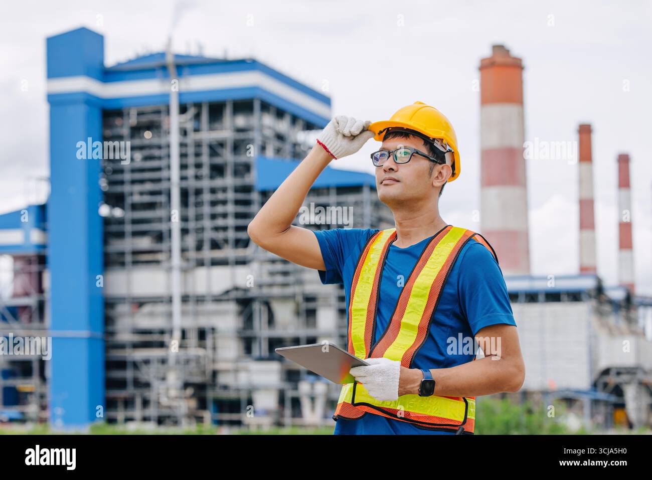 Ingénieur professionnel travailleur masculin avec centrale à charbon, centrale électrique avec fond vert de nature Banque D'Images