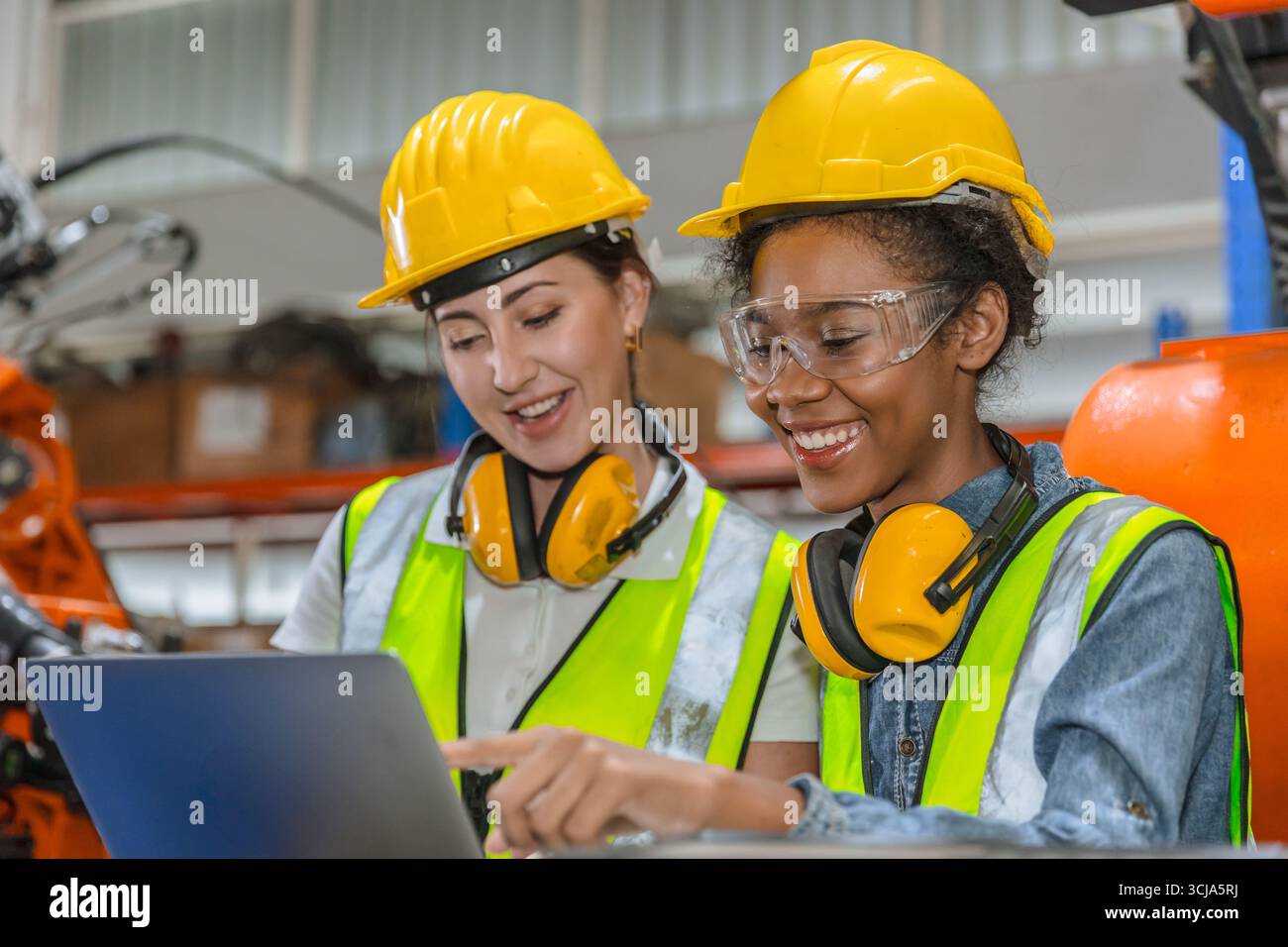 formation d'ingénieur robotique, travail de technicien dans l'opérateur de contrôle de machine de bras de soudage de robot industriel moderne d'usine Banque D'Images