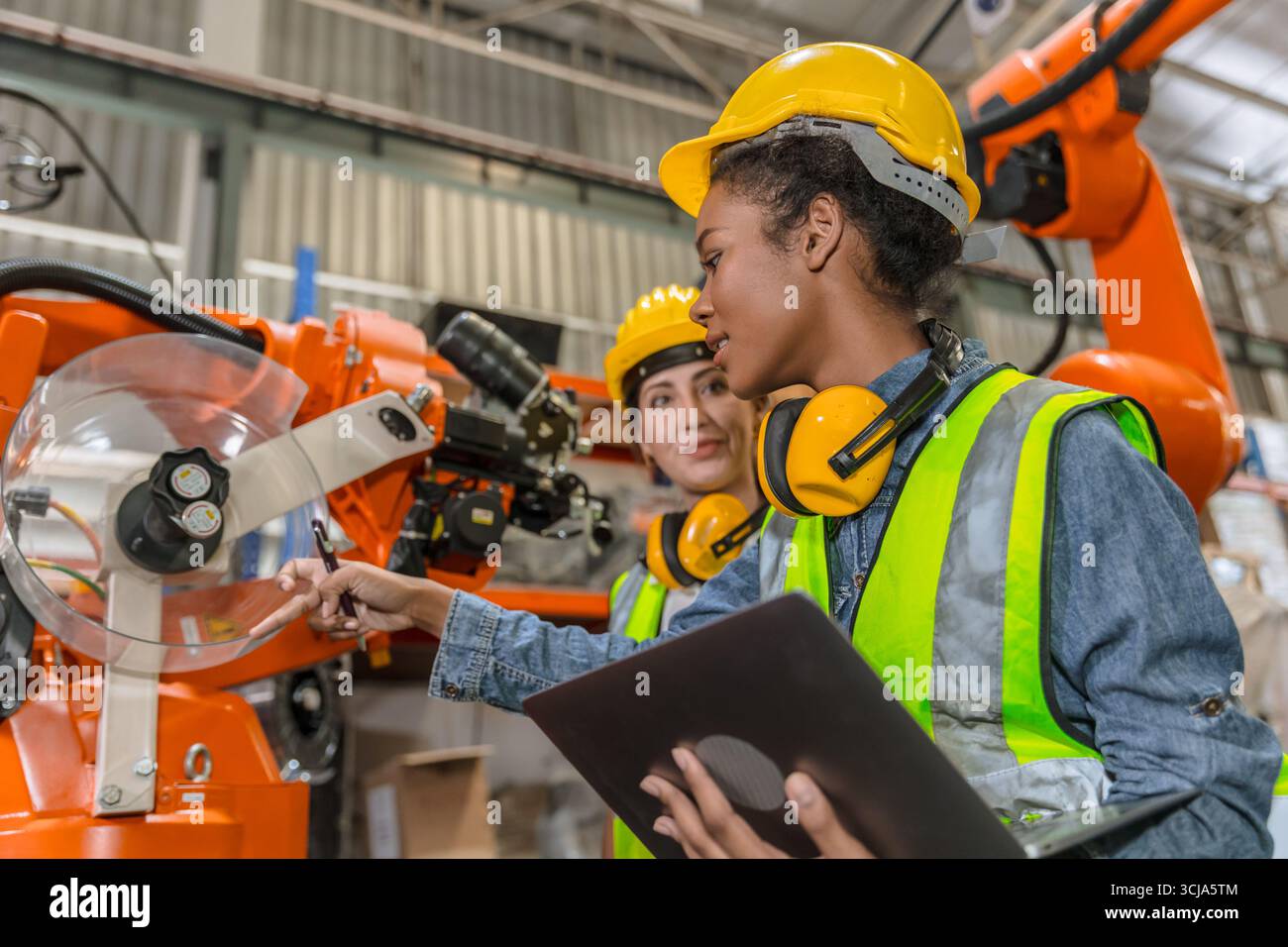 formation d'ingénieur robotique, travail de technicien dans l'opérateur de contrôle de machine de bras de soudage de robot industriel moderne d'usine Banque D'Images