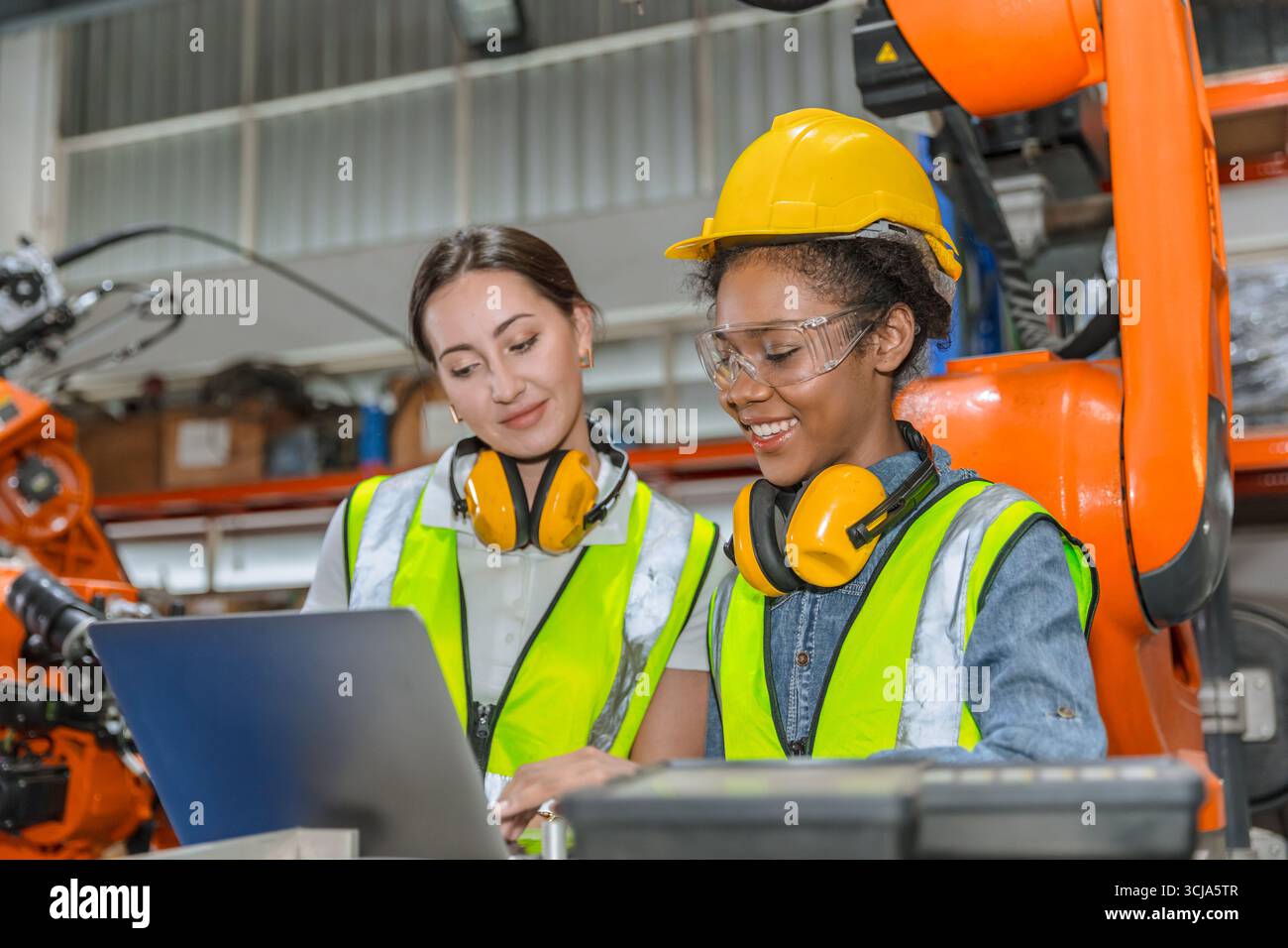 formation d'ingénieur robotique, travail de technicien dans l'opérateur de contrôle de machine de bras de soudage de robot industriel moderne d'usine Banque D'Images