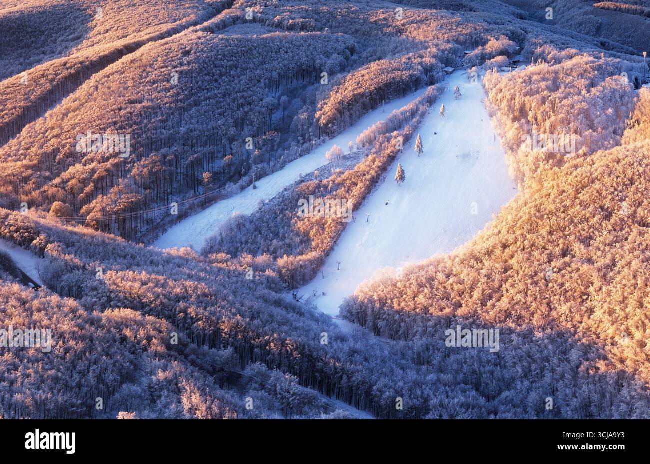 Neige sur une piste de ski à la station de ski par une journée ensoleillée d'hiver Banque D'Images