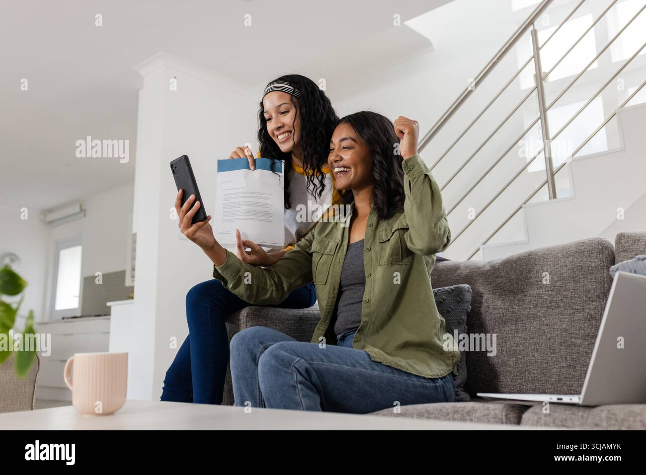 Célébrant le succès, la mère afro-américaine et l'enfant appel vidéo sur smartphone Banque D'Images