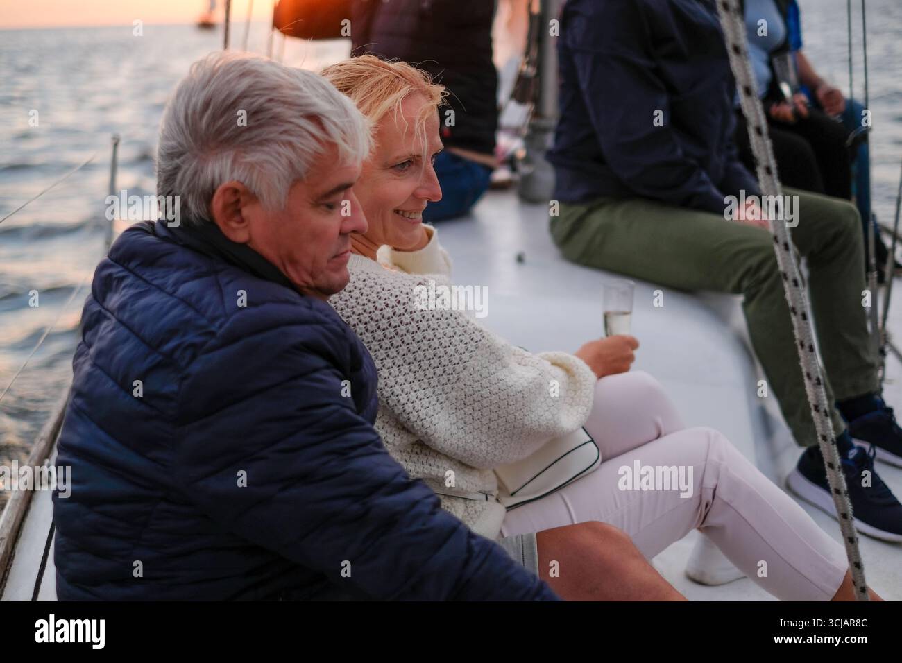 Couple plus âgé partage un moment joyeux tout en naviguant sur des eaux calmes, exsudant l'élégance et le bonheur, entouré par la beauté de la nature et la soirée l Banque D'Images