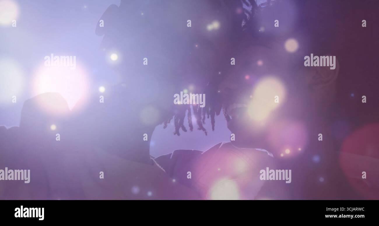 Regardant dreadlocked homme et femme avec des tresses face à face dans le studio, avec des lumières bokeh incandescentes Banque D'Images
