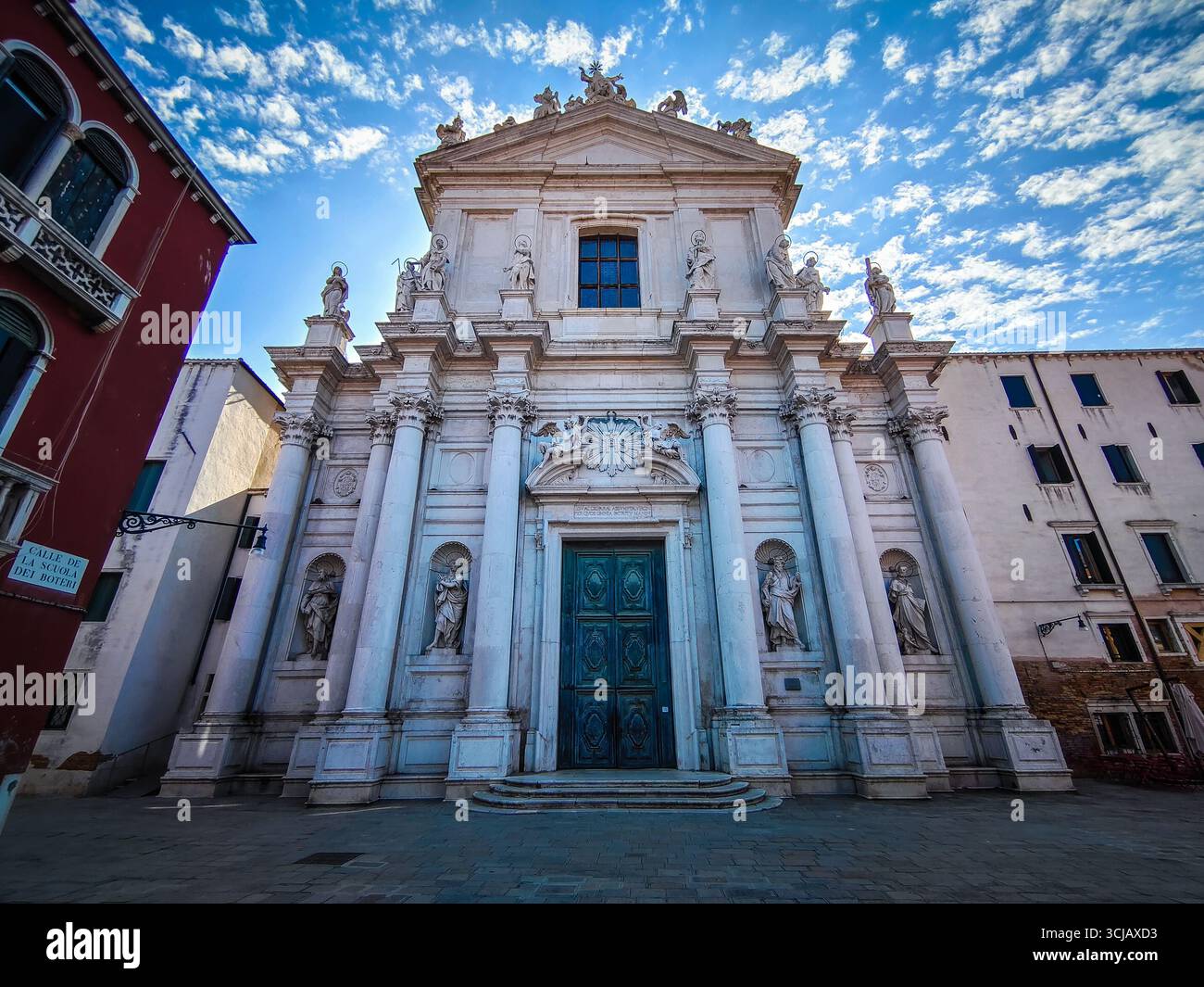 Une photo grand-angle et basse de la façade ornée d'une église historique de Venise. La photographie met en valeur les détails complexes du marbre blanc Banque D'Images