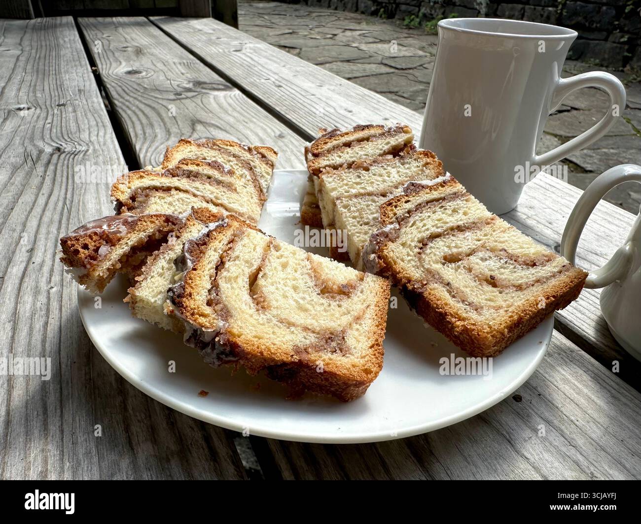 Morceaux de noix sur une assiette blanche sur un banc avec deux tasses à côté Banque D'Images
