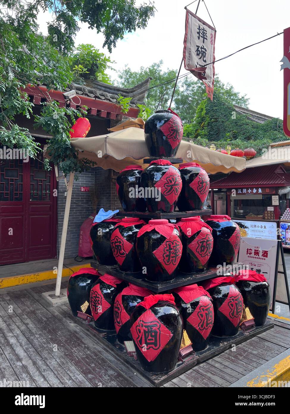 Des bocaux à vin traditionnels empilés dans une exposition pyramidale sur un marché local de Xi’an, en Chine, mettant en valeur le patrimoine culturel. Banque D'Images