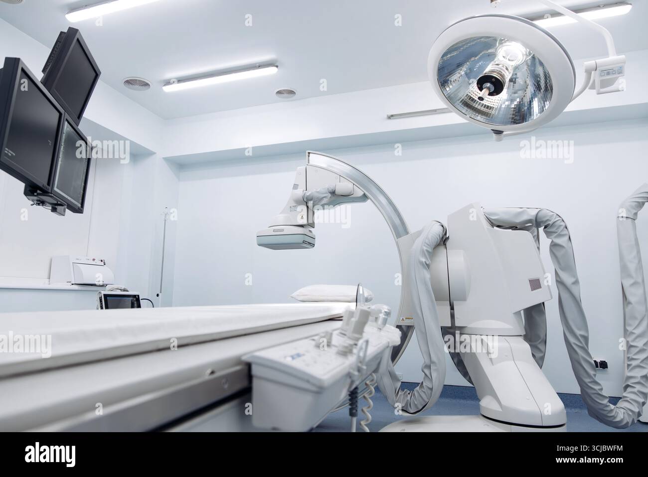 Machine d'angiographe positionnée dans un établissement médical contemporain, présentant une technologie d'imagerie avancée, des lumières chirurgicales lumineuses et un ster impeccable Banque D'Images