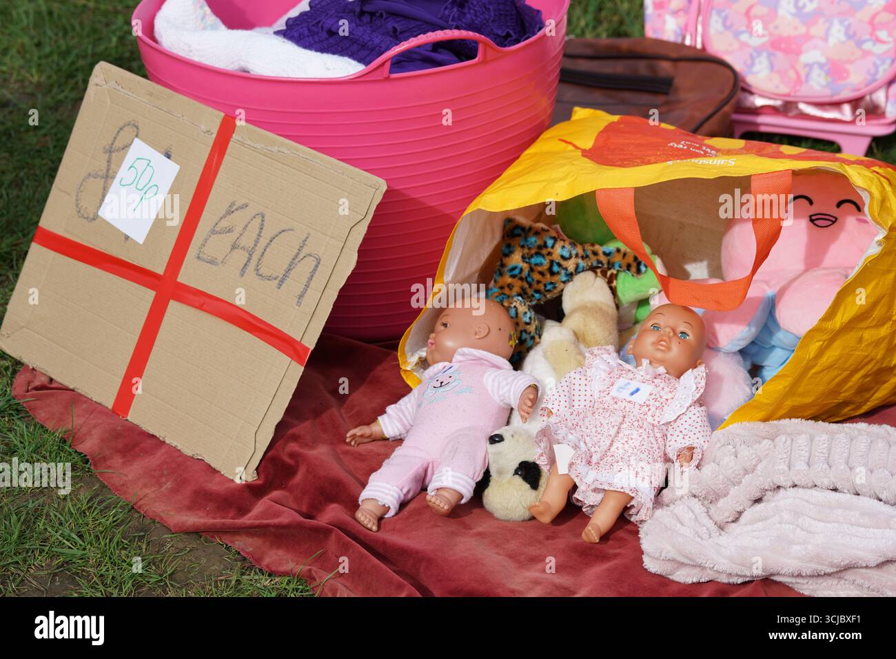 Poupées et jouets pour bébés exposés en vue de la vente lors d'un événement de vente dans une cour communautaire. Faygate, Horsham, Angleterre Banque D'Images
