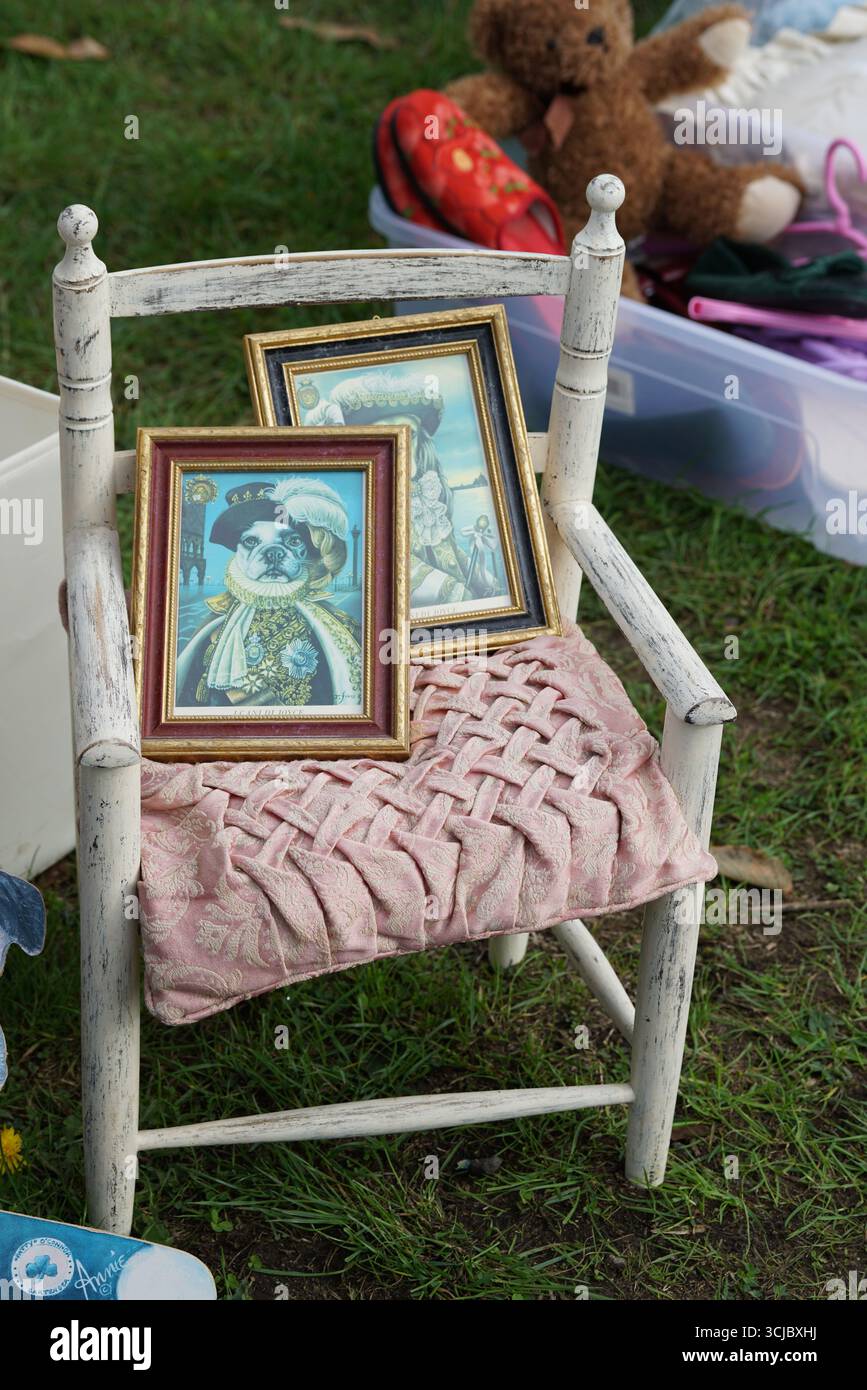 Chaise en bois vintage avec portraits de chien encadrés à la vente extérieure. Faygate, Horsham, Angleterre Banque D'Images