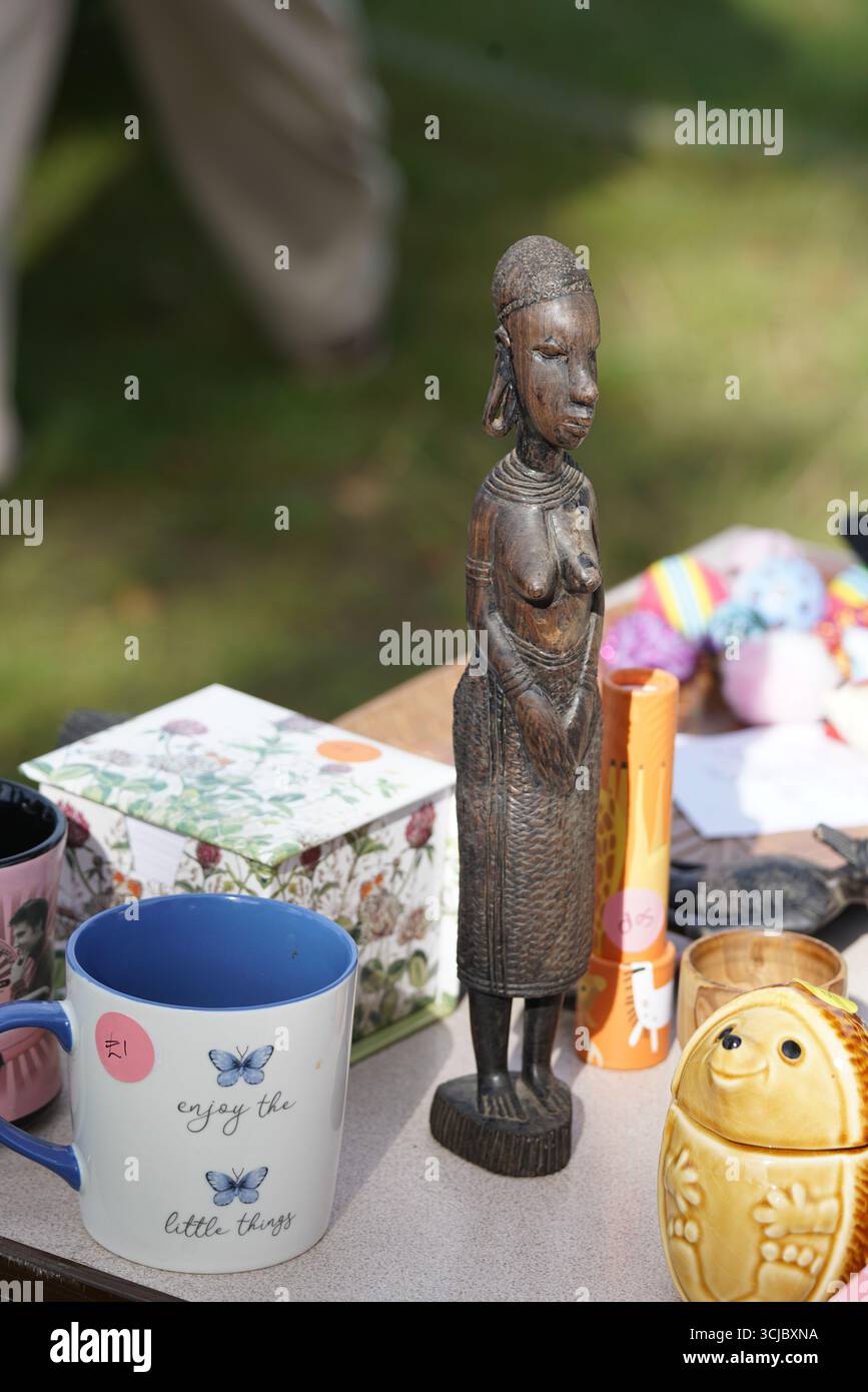 Figurine en bois et objets assortis sur une table à un marché aux puces. Faygate, Horsham, Angleterre Banque D'Images
