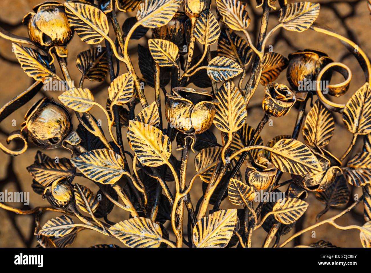 Décoratif, forgé, treillis en acier en forme de fleurs roses avec des tiges et des pétales, peint dans la couleur du bronze vieux. Banque D'Images