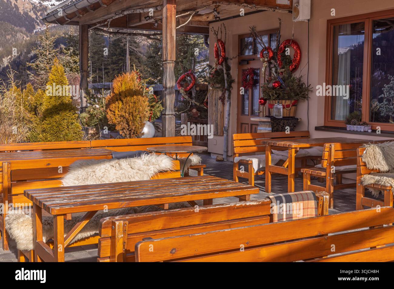 Un restaurant alpin confortable en Autriche, orné de décorations de Noël festives. Les bancs et les tables en bois offrent un charme rustique contre l'étonnant Banque D'Images