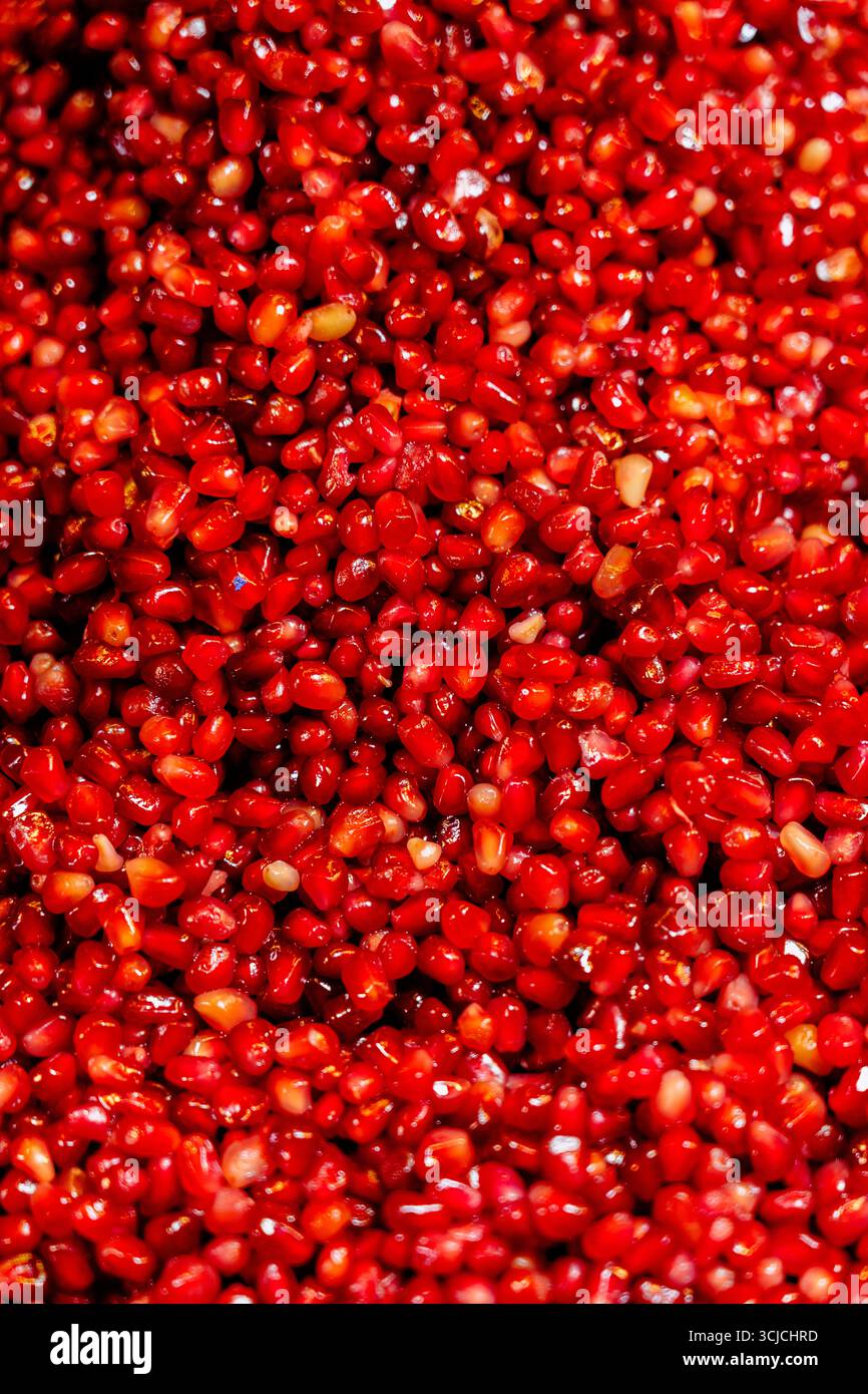 Une vue rapprochée des graines de grenade rouges vibrantes, symbolisant la santé et l'abondance. Ces graines juteuses sont un fruit populaire dans les cultures du moyen-Orient A. Banque D'Images