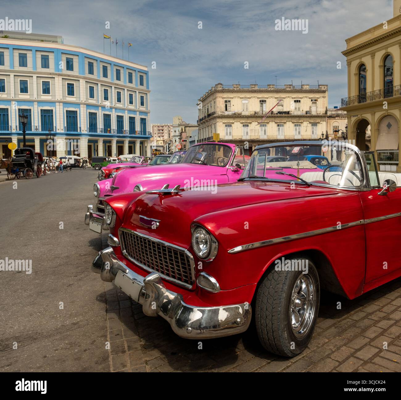 Des voitures anciennes vibrantes bordent les rues de la Havane, Cuba, mettant en valeur un mélange coloré de design automobile classique et de culture cubaine. Ces taxis sont iconi Banque D'Images