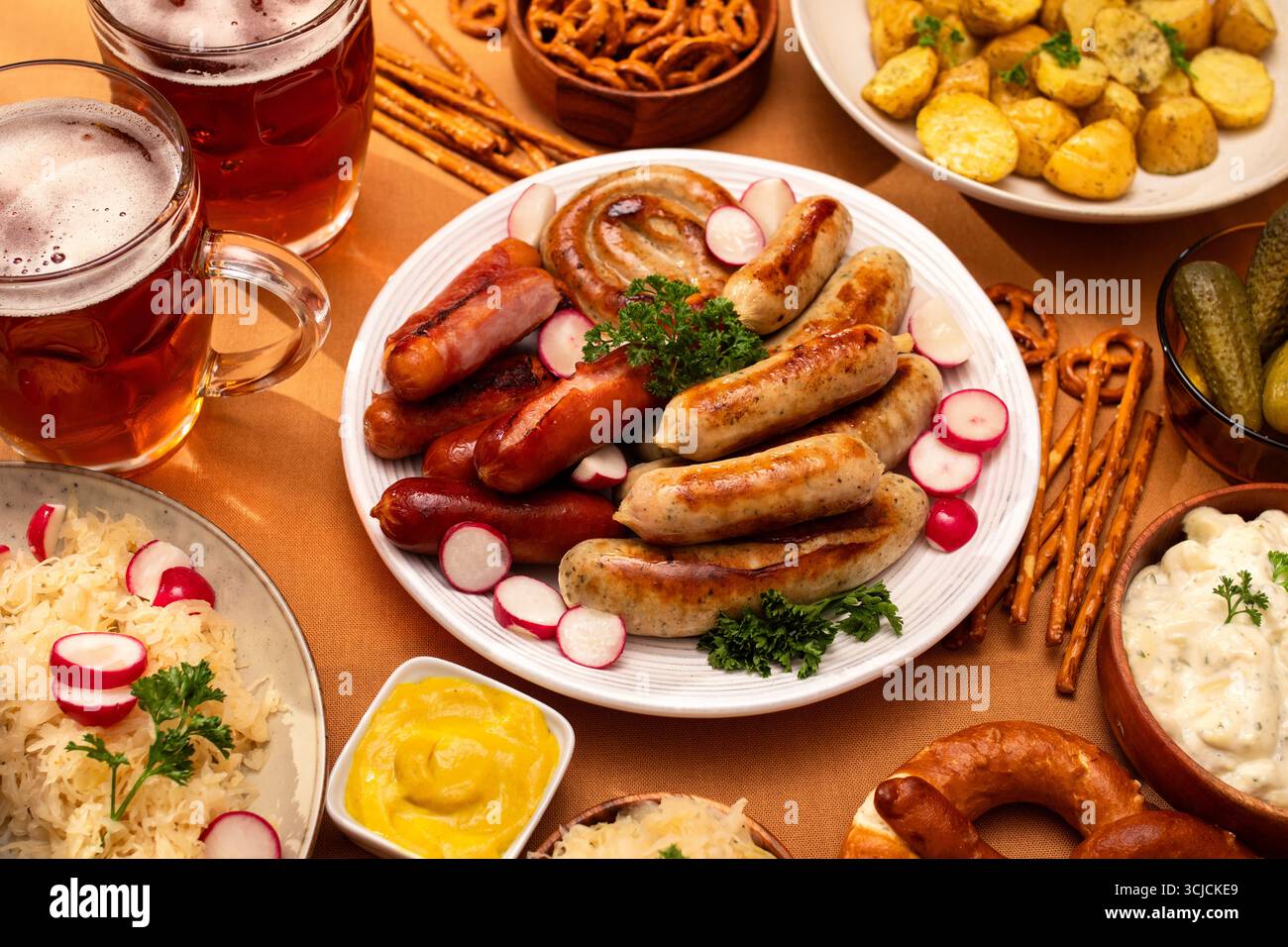 Festin allemand traditionnel avec saucisses grillées, choucroute, salade de pommes de terre et bretzels. Servie avec des tasses de bière, cette tartinade célèbre la flav Banque D'Images