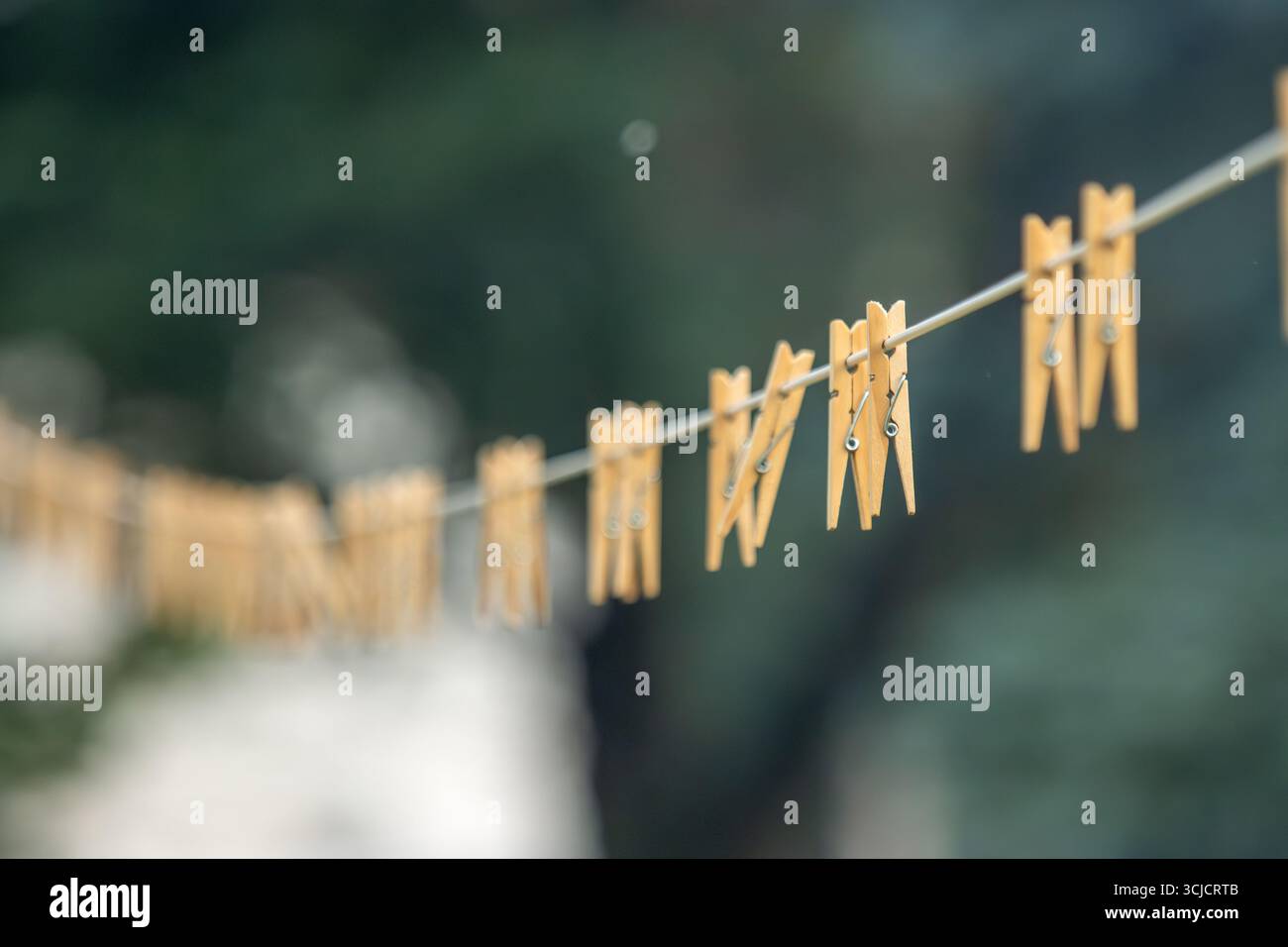 Pinces à linge en bois sur une corde à linge blanche Banque D'Images