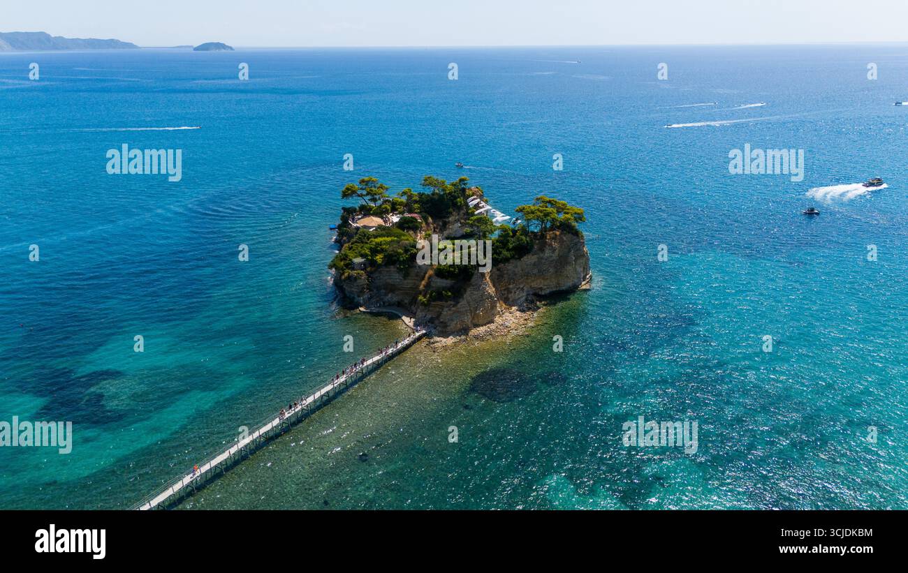 Vue aérienne de l'île de Cameo Zakynthos Grèce avec des eaux bleu cristal et turquoise pont en bois et bateaux naviguant autour de l'îlot pittoresque Banque D'Images