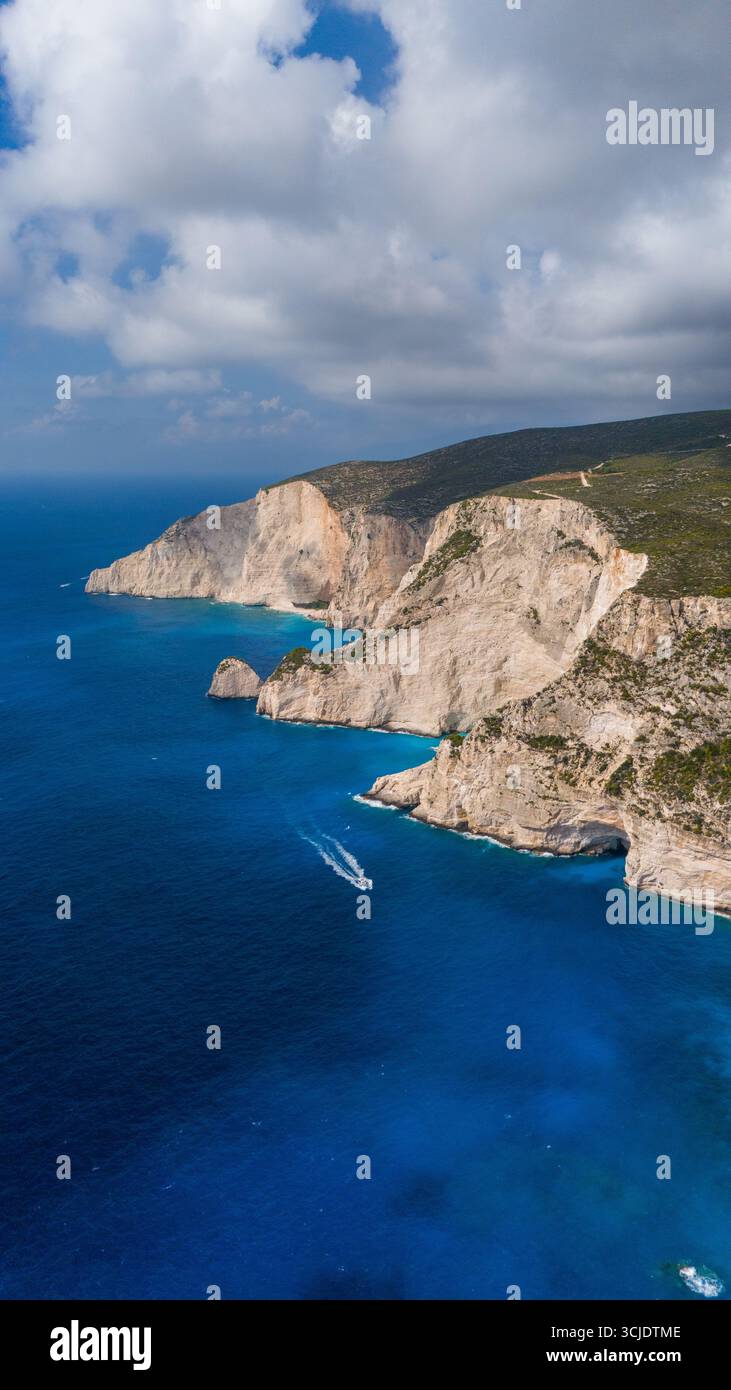 Vue imprenable sur les falaises blanches de Zakynthos Grèce s'élevant de la mer Ionienne turquoise avec route côtière sinueuse et collines verdoyantes au-dessus Banque D'Images