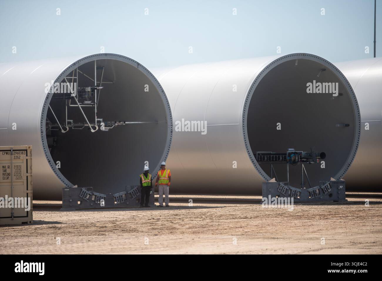 Chantier de construction avec grues assemblant des éoliennes offshore, mettant en valeur les énergies renouvelables, les technologies vertes et les infrastructures énergétiques durables. Banque D'Images