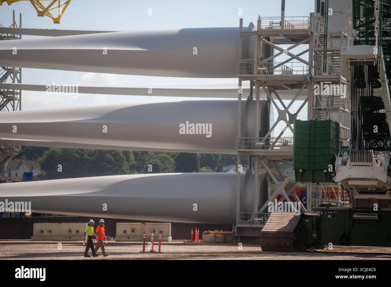 Chantier de construction avec grues assemblant des éoliennes offshore, mettant en valeur les énergies renouvelables, les technologies vertes et les infrastructures énergétiques durables. Banque D'Images